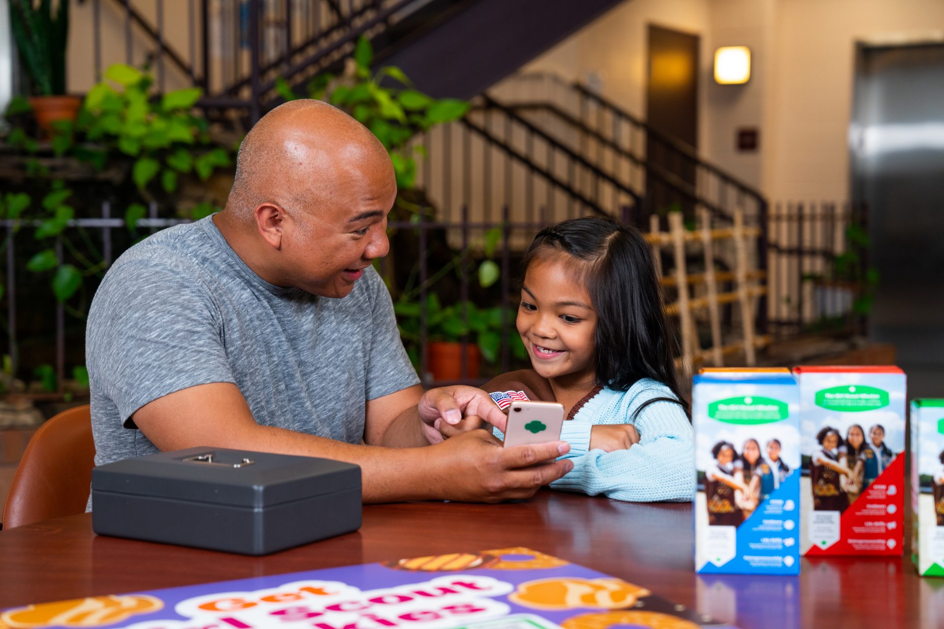 girl scout selling cookies with parent