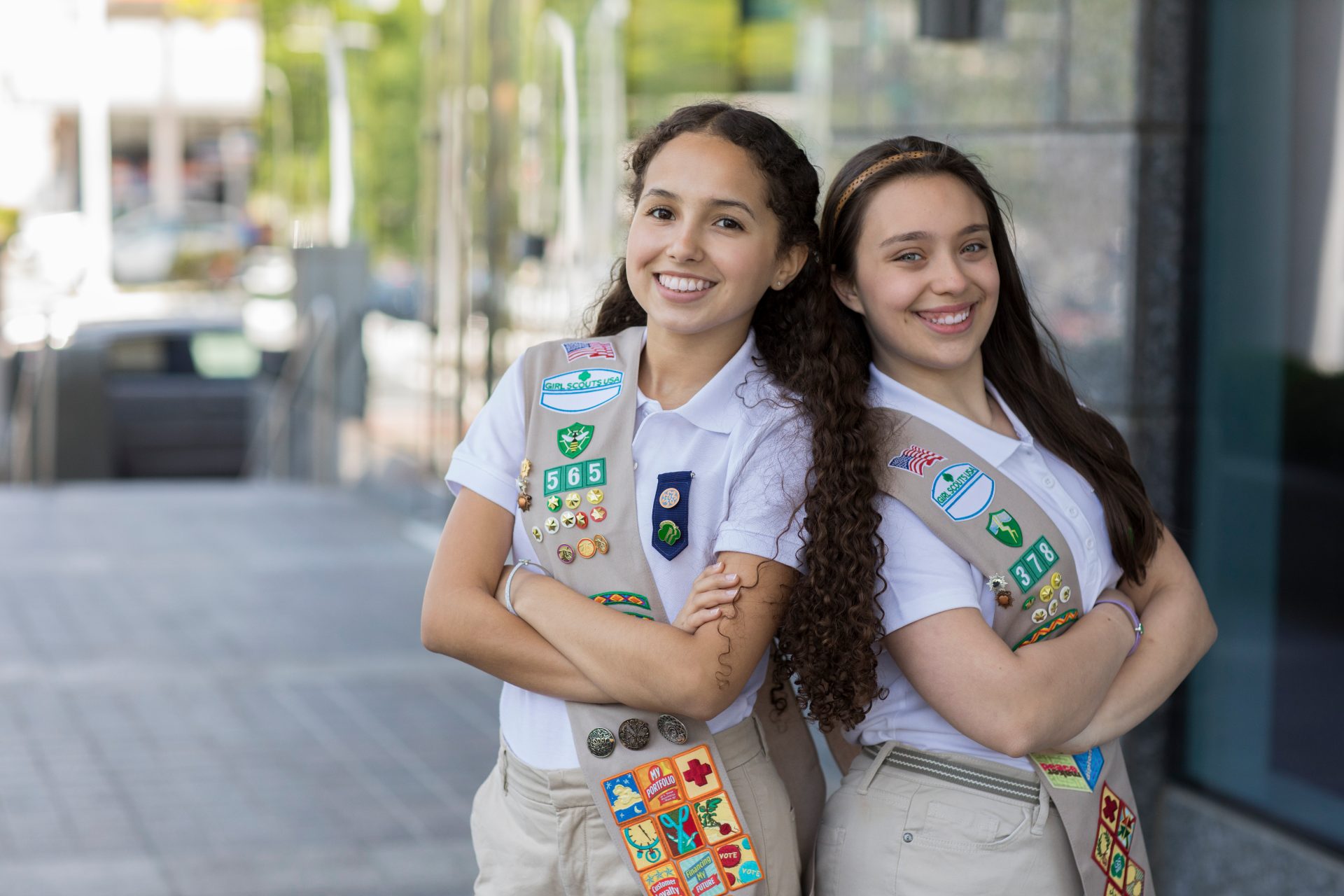 ambassador high school girl scout wearing sash outside against green background