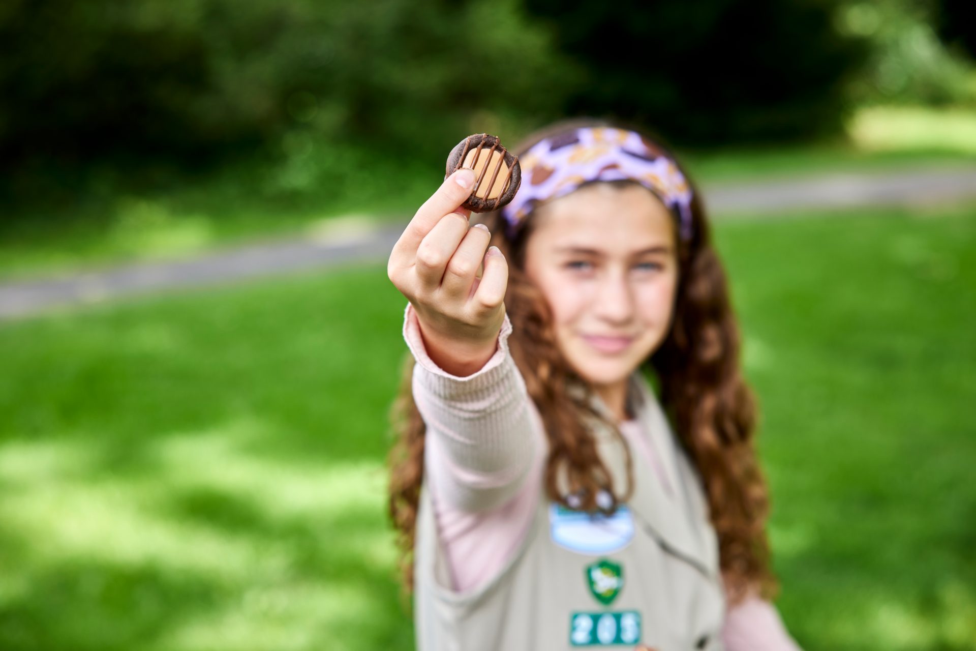 adult volunteer and girl scout sitting at table looking on phone at digital resources